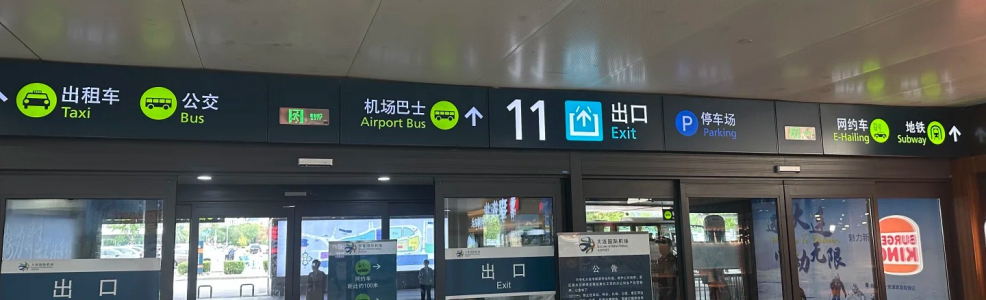 Airport exit signs showing taxi, bus, airport shuttle bus, parking, ride-hailing and subway directions