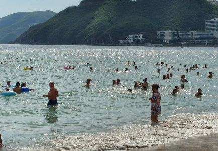 Crowded Dadonghai seashore with swimmers in the water