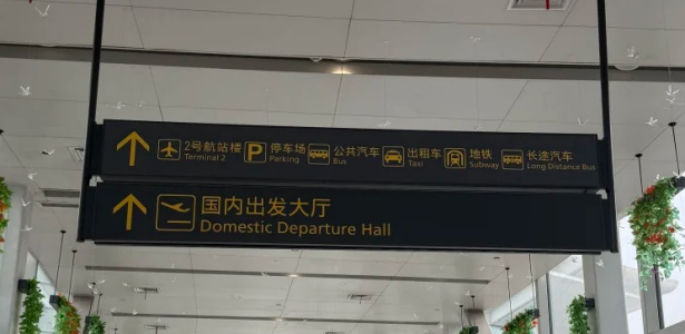Direction sign for taxi stand, domestic departures, subway, and airport buses