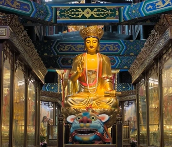 Golden Buddha statue inside Fuhu Temple on Mount Emei