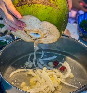 Coconut chicken soup being prepared with fresh coconut water